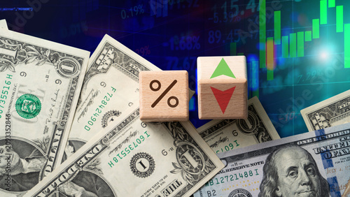 Foto Bar charts, financial data tables, wooden cubes showing percentage and arrow symbols over US dollar banknotes, and a stock market screen
