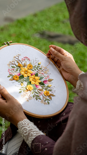 Portrait  Artisan Hands Embroidering Flower Pattern on Hoop in Sunny Backyard