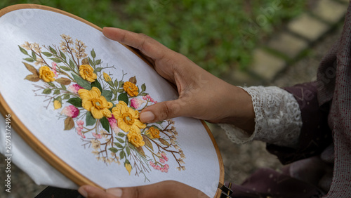 Female Artisan Hands Embroidering Flower Pattern on Hoop in Sunny Backyard