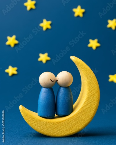 Wooden Figures in a Romantic Pose on a Yellow Crescent Moon Surrounded by Stars, Representing Mental Wellness and Self-Care for Emotional Harmony