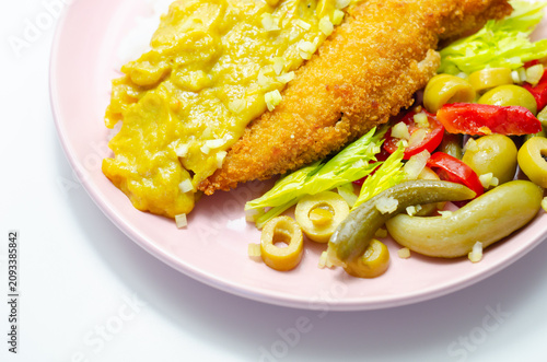 Golden-breaded fish rests on a pink plate