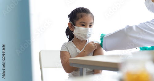 Asian little girl getting dengue vaccine. Pediatrician. pediatric checkup in hospital children medical care Doctor pediatric holds an injection vaccination the child.