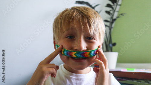 A boy holding a diamond mosaic bracelet craft close-up