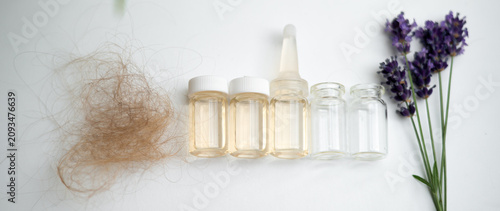 Tableau sur toile Hair loss serum ampoules, empty vials, a clump of shed hair and a lavender sprig