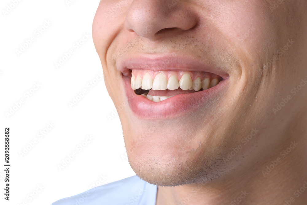 Fototapeta premium Happy young man with healthy teeth on white background, closeup