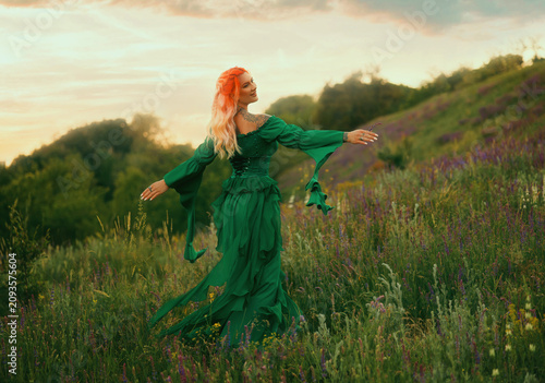 Happy fantasy woman medieval queen spinning dancing walking in summer nature field. elf girl princess have fun running at forest path green grass trees sunset sky. fairy lady, long dress looking back
