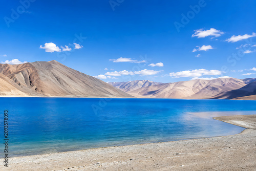 Pangong Lake, Ladakh, India, vivid blue lake with barren mountains and bright open sky