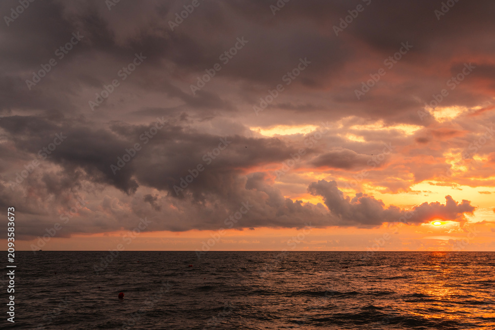 Fototapeta premium Sunset over the sea after rain with thunder clouds. Sky background.