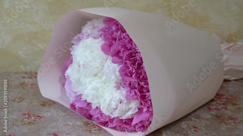 A beautiful bouquet of pink and white peonies in a paper wrapper, A festive bouquet of white and pink flowers in a gift box