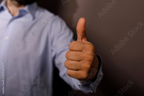 Photography A close up of a man showing a thumbs up for approval and agreement