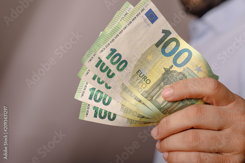 Man holding a fan of 100 eu...
