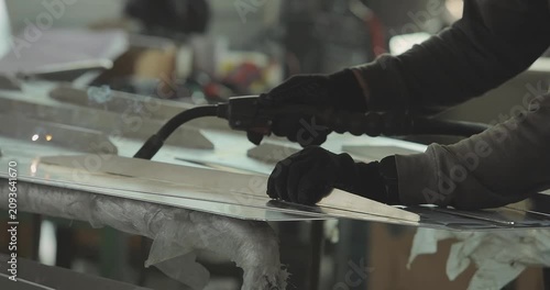 Welding of aluminum parts or equipment components. Welder weld a aluminum boat hull. Production of an aluminum hull for a motorboat. Close-up. Welding process in the shop. Shipyard