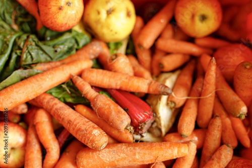 Foto A pile of fresh organic carrots with apples and greens, vibrant and healthy