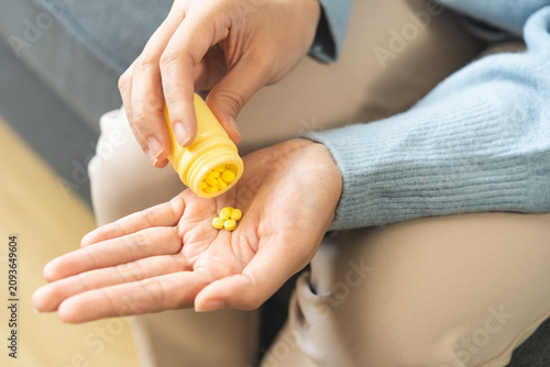 Cuadro en lienzo Sick asian young woman, girl holding tablet pill on hand pour from medication bottle, painkiller for allergy medicine, sleep pills or ache pain, stress for treatment, take drug