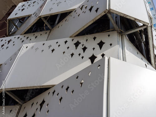 Konstfotografi Modern white perforated metal building facade with star shaped cutouts in sunlig