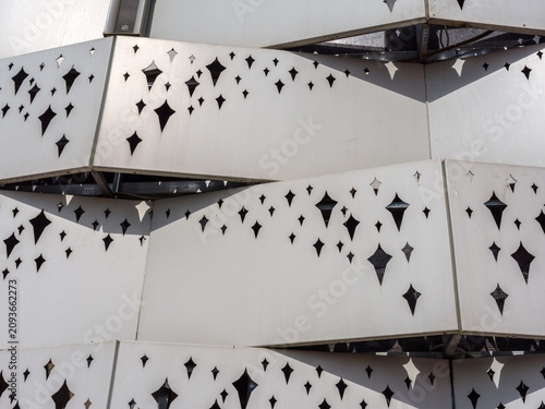 Konstfotografi Contemporary white metal building cladding featuring geometric star cutouts in b