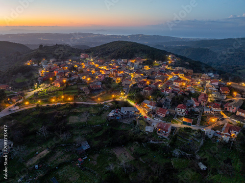 Breathtaking aerial sunset over Sokraki village nestled in mountains with dramatic horizon and golden light covering the landscape in Corfu Greece