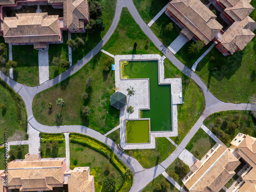 Aerial Top Down View of Geometric Swimming Pool and Resort Architecture Gardens in Corfu Greece