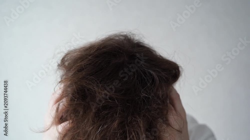 Static Shot Of Distressed Woman Holding Head And Closing Eyes In Bedroom Interior With Plain Wall Background During Stressful Morning Routine.