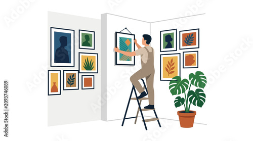 A man hangs a framed picture on a wall while standing on a stepladder in an art gallery.
