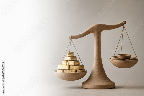 Scale balancing gold bars and bowls. Space for text.