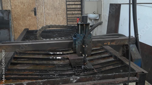 The process of plasma cutting metal on a CNC machine in the production room of the workshop
