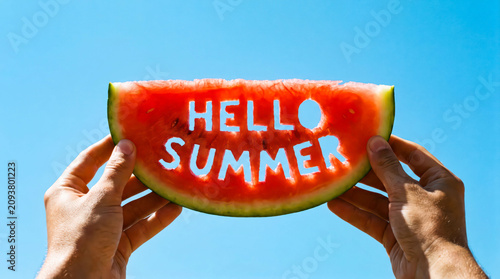 Person holding watermelon slice with hello summer text