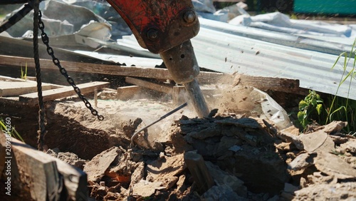 Foto Hydraulic breaker attachment on an excavator crushing concrete and rebar during