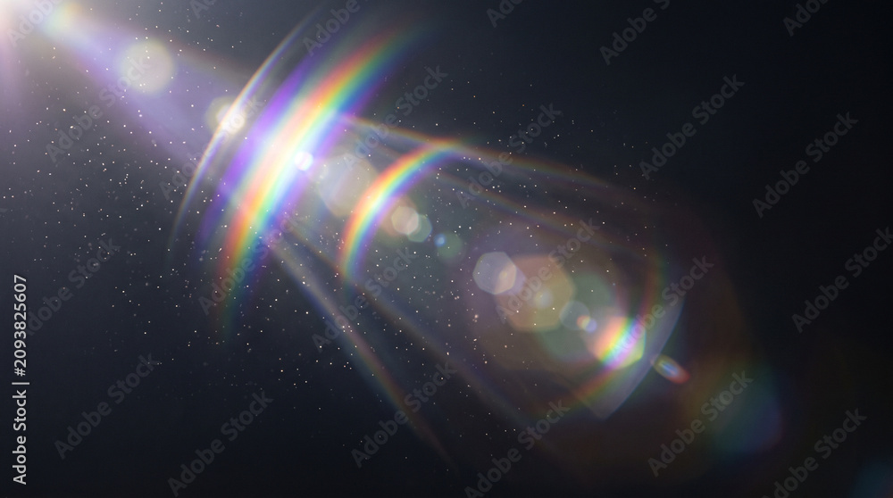 Obraz premium Rainbow light beams shining through a dark space with sparkling particles and lens flares everywhere