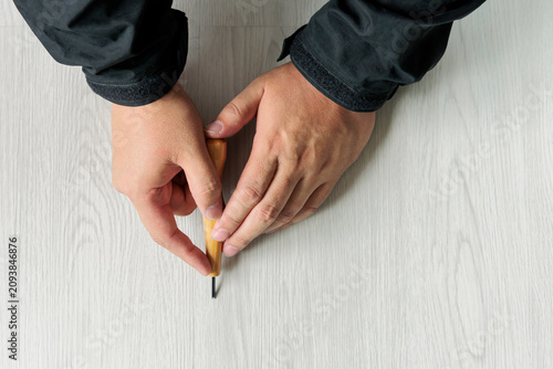 Cuadro en lienzo 傷んだ木目調床材の補修箇所にキリで印をつける職人の手元の俯瞰