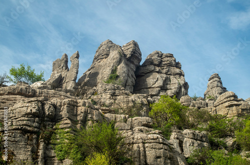 Majestic limestone pillars and pancake rock formations against blue sky in El Torcal de Antequera, Spain