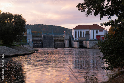 Hydroelectric dam at sunset with water reflections