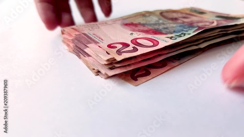 Horizontal 4K video close up. Female hands stacking paper banknote into stack on white table. Woman counts Georgian cash money twenty lari. 20 GEL bill. Concept of salary, pay tax, buy, debt, loan