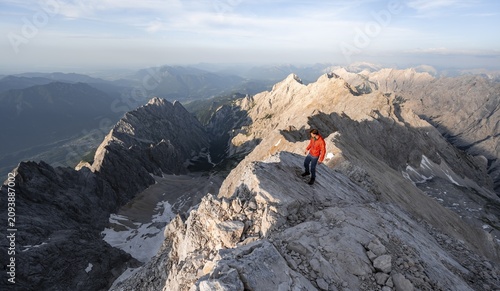 Mountaineers on a steep rocky ridge, impressive mountain landscape, view of the Höllental and the Alpspitze from the Jubiläumsgrat, in the evening light Zugspitze, Wetterstein range, Bavaria, Germany