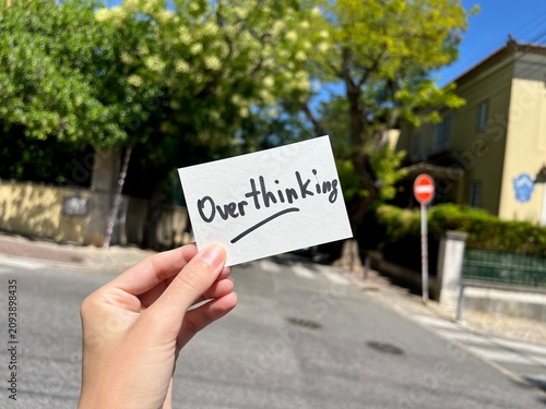 Overthinking - hand with text on the street in background, psychology issues concept