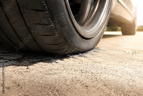 Car tires parked on scorching concrete rubber soft and sticky at contact patch pure visual