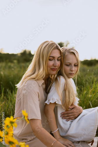 Canvastavla Mother and daughter embracing tenderly in a sunlit meadow with sunflowers