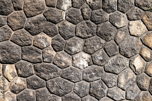 Close-up of a rustic wall built from irregular natural stones, creating a detailed rock texture background for architecture, construction, and design projects.