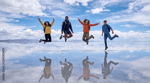 four diverse people jumping on the Uyuni salt flats in Bolivia