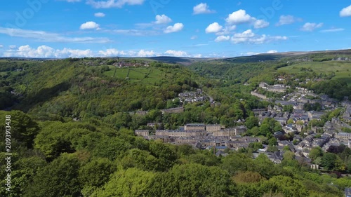 aerial panning view of hebden bridge and heptonstall in summer surrounded by trees and fields