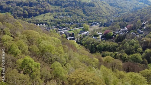 high aerial view of Mytholm at the end of Hebden Bridge in West Yorkshire in bright spring sunlight under a wooded hillside