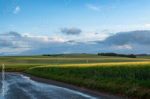 Konstfotografi rainbow and undulating hills in countryside of thierache in the north of france
