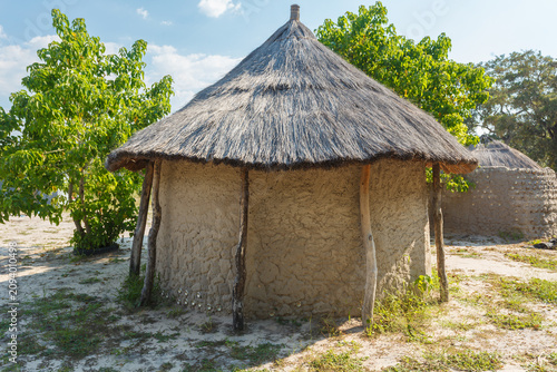 Fotografie Closeup of traditional round mud hut with thatched roof of natives of Botswana,