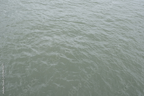 Fotografie Surface of calm, murky water with subtle wave patterns