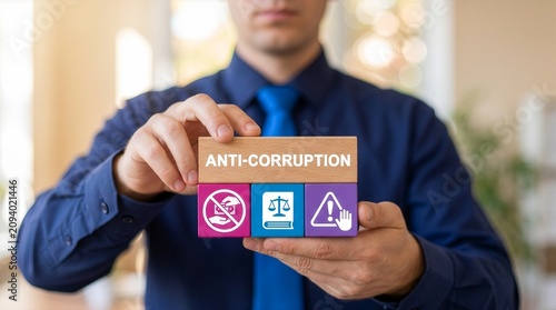 Business person holding colorful blocks with icons sees inscription ANTI-CORRUPTION. Concept of anti corruption activities that oppose or inhibit corruption. International anti-corruption. New