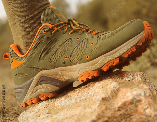 Outdoor Adventure Featuring Olive Hiking Shoe on Rock with Orange Accents and Laces from Right Viewpoint in Natural Environment