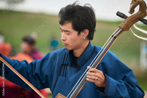 Foto A musician dressed in Mongolian attire playing the morin khuur (horsehead fiddle