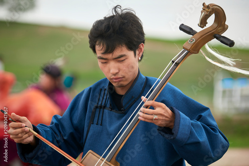 Canvastavla A musician dressed in Mongolian attire playing the morin khuur (horsehead fiddle