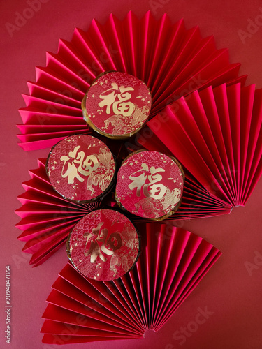 Symbolic Lunar New Year arrangement of traditional cakes and red folded paper fans representing prosperity