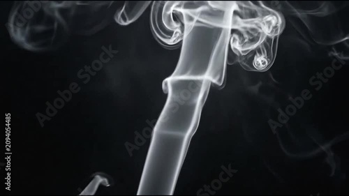 Elegant white smoke rising and swirling on black background